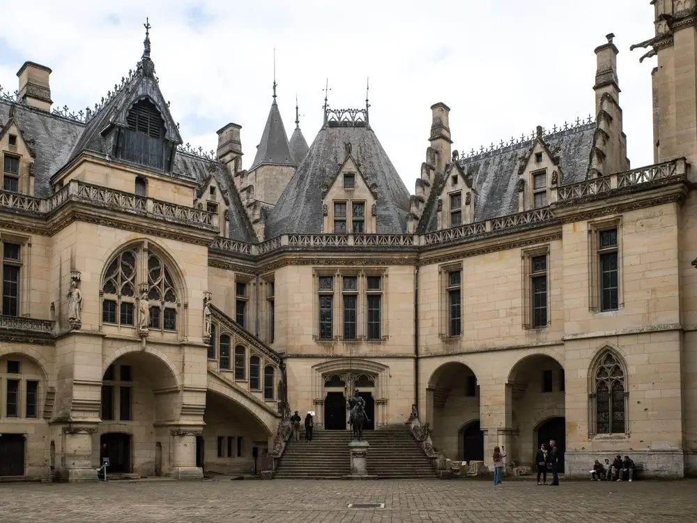 The inner courtyard of Château de Pierrefonds, its gabled façades rising above a broad flight of steps